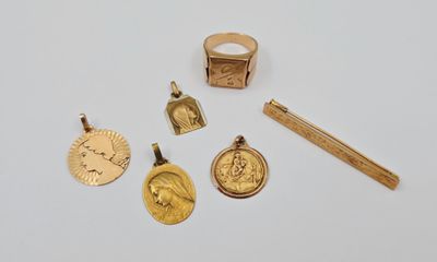 plusieurs bijoux en or, dont une bague, un stylo et une médaille
