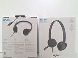two boxes of headphones sitting on top of each other on a table