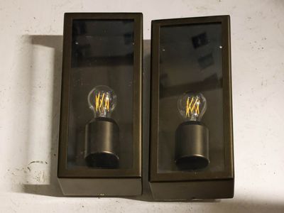 two light bulbs that are on the wall next to each other