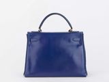 a small blue leather handbag with a gold handle