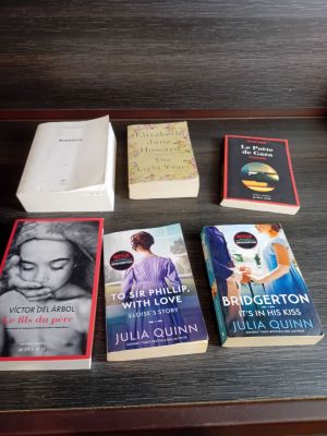 Plusieurs livres sont posés sur une table, à côté d'une tasse de café