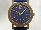 une montre bleue avec des aiguilles dorées et un bracelet bleu