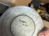 a person holding a white bowl in their hand