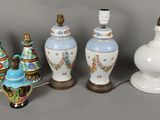 Plusieurs vases et lampes sont alignés sur une surface grise