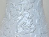 a white vase with a dragon design on it