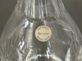 a glass vase with a label on it on a table