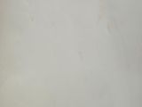 the back of a white refrigerator freezer sitting on top of a counter