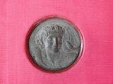 a close up of a silver coin on a pink cloth
