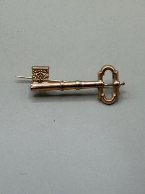 une image représentant une clé en or sur laquelle figure un nœud