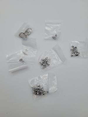 a lot of small silver and black beads on a white surface