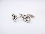 a pair of silver cufflinks on a white background