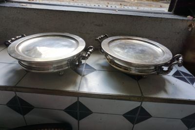 deux plateaux en argent posés sur un comptoir devant une fenêtre