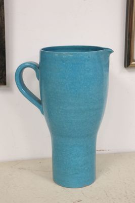 a blue cup sitting on a table next to a picture