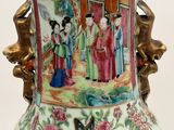 a vase with a painting on it sitting on a table