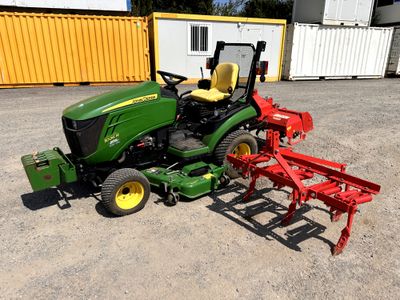 Le tracteur est garé à côté de la charrue sur le parking.