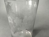 a glass with a design on it sitting on a table