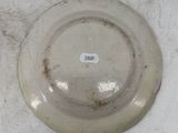 a white plate on the floor with a sticker on it