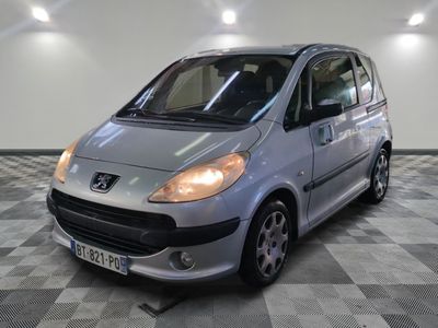 une petite voiture argentée garée dans une pièce au sol carrelé en damier