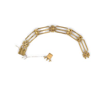 un gros plan d'un bracelet en or auquel est attachée une chaîne
