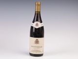 une bouteille de vin posée sur une table blanche