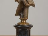 a bronze statue of a woman sitting on top of a table