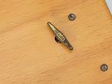 a small metal object on a wooden table next to a laptop
