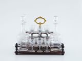 a set of wine glasses and a decanter on a wooden stand