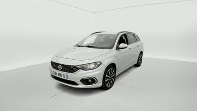 Une voiture blanche est garée dans une pièce blanche au sol blanc.