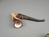 a pipe that is sitting on a table next to a figurine of a man