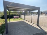 une structure métallique avec un banc au milieu d'un parking