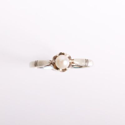 an image of a white pearl ring on a white surface