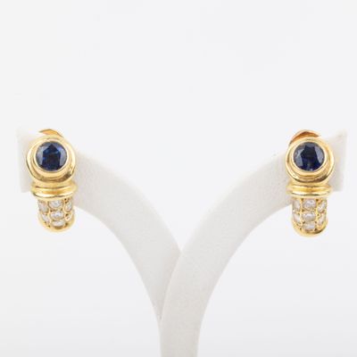 pair of sapphire and diamond earrings on a white stand
