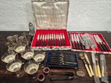 many different types of knives and spoons in a case
