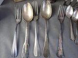 a lot of silver spoons and forks on the table