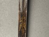 a close up of a knife on a table with a black background