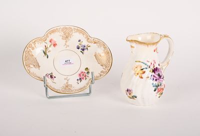 a small pitcher and a small plate sitting next to each other