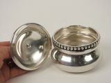 someone is holding a silver cup with a lid on it