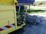 a yellow dump truck parked next to a blue dump truck