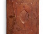 an old leather book with a decorative design on the cover