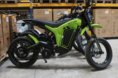 une moto verte et noire garée dans un entrepôt