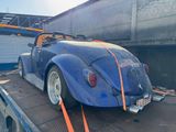 a blue car on the back of a flatbed truck