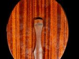 a wooden plaque with a knife in it on a black background