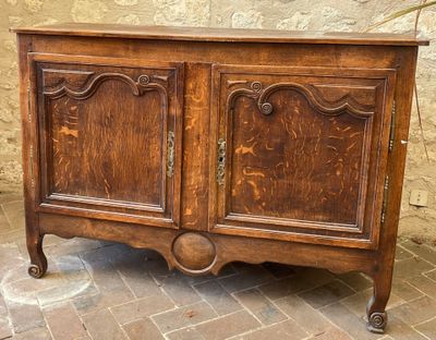a wooden cabinet that is sitting on a brick floor
