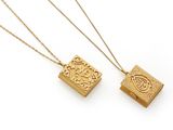 a pair of gold necklaces on a white background