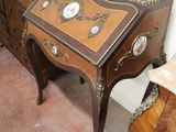 a small table with a clock on it next to a dresser