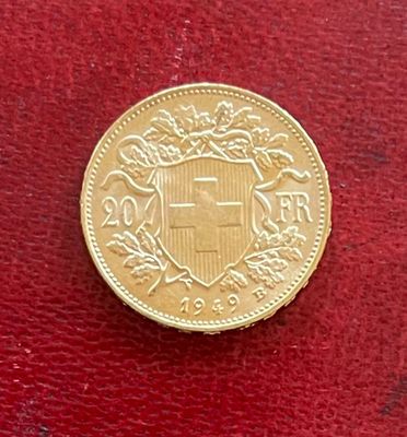 gros plan d'une pièce d'or sur une surface rouge