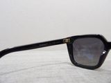 a pair of black sunglasses sitting on a white surface