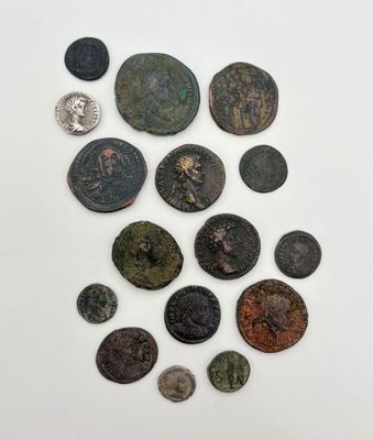 un ensemble de pièces de monnaie anciennes posées sur une surface blanche, sur fond blanc
