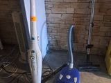 un aspirateur et une serpillière posés sur le sol d'une pièce
