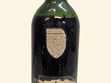 une vieille bouteille d'alcool posée sur une surface blanche